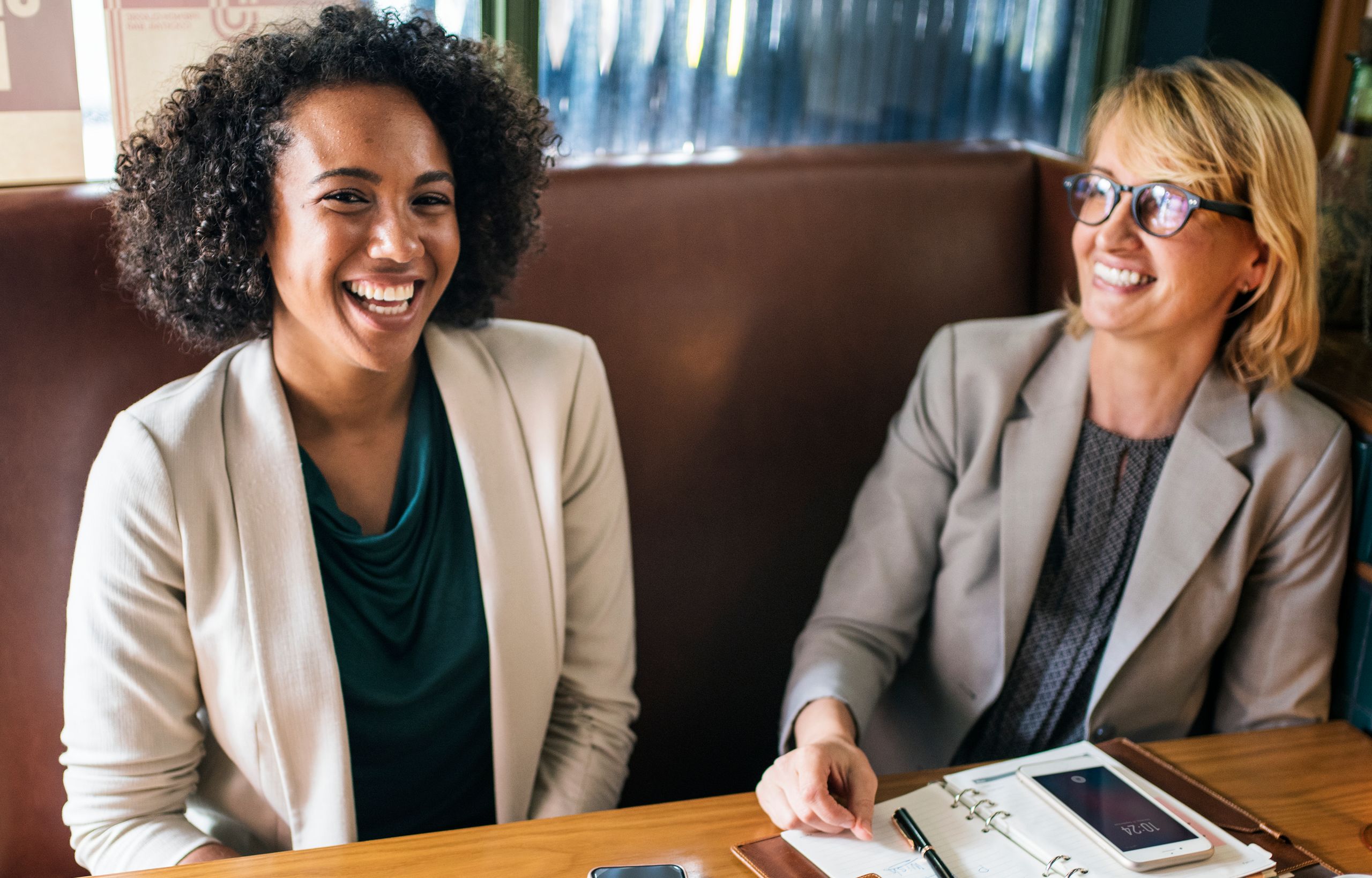 Two women laughing together after coaching session