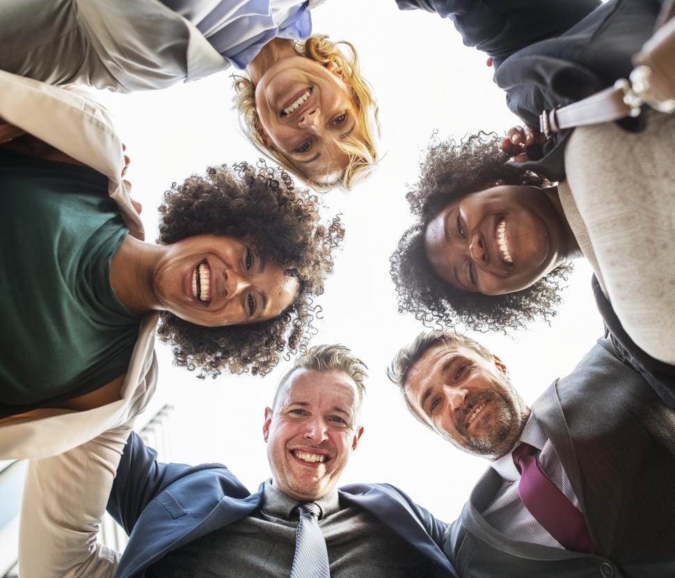Diverse team huddle smiling together